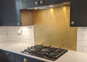 aged brass splashback with patina in grey kitchen