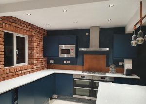 aged copper splashback in modern blue kitchen